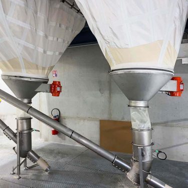 Vis souple connectée à un silo souple pour le transfert de poudre